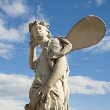 Ancient sculpture angel in the blue sky. clipart
