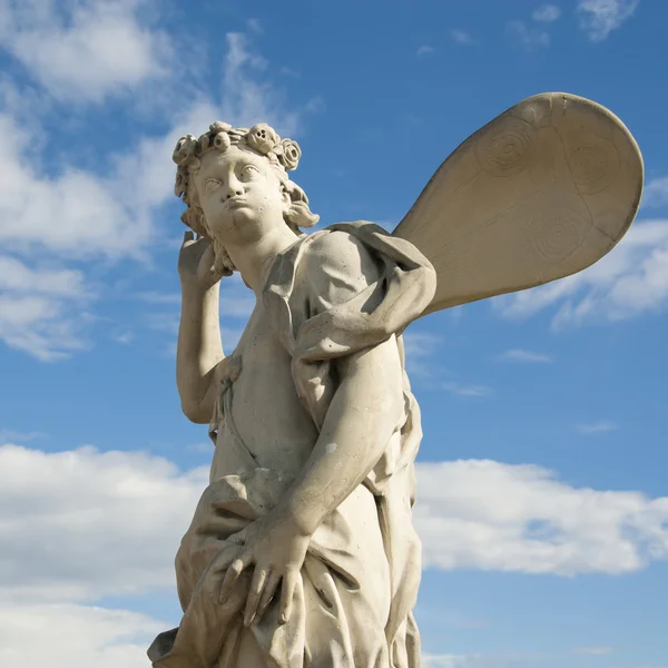 Oude sculptuur engel in de blauwe hemel. — Stockfoto