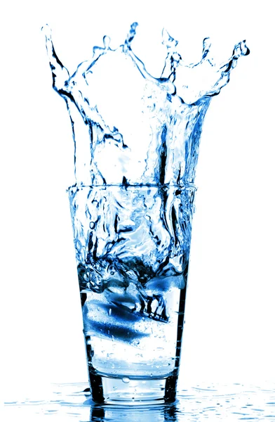 Eiswürfel spritzten in Wasserglas — Stockfoto