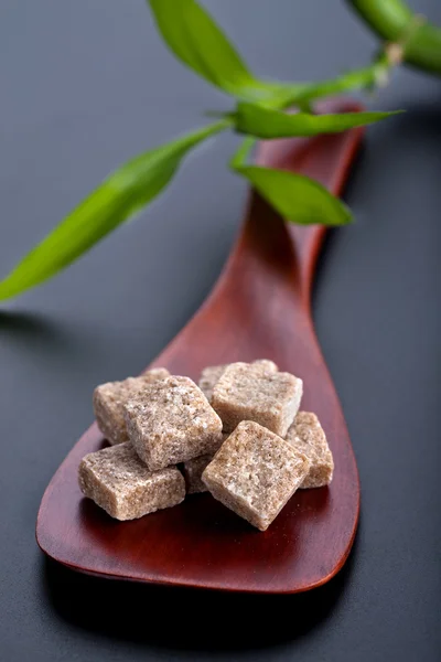 Wooden spoon with brown sugar cubes — Stock Photo, Image