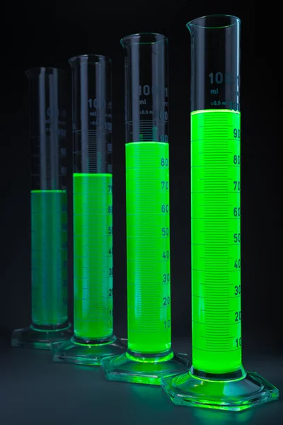 Green liquid in cylinders — Stock Photo, Image