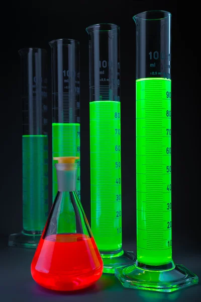 Verde em cilindros frasco vermelho — Fotografia de Stock