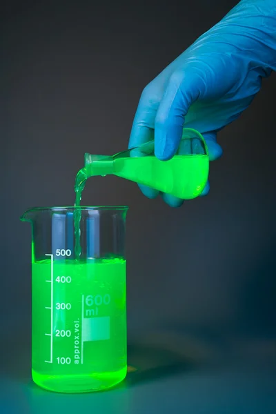 Green pouring from flask — Stock Photo, Image