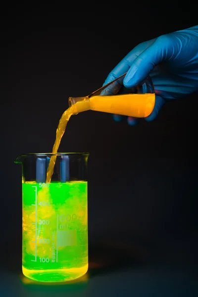 Yellow pouring from flask — Stock Photo, Image