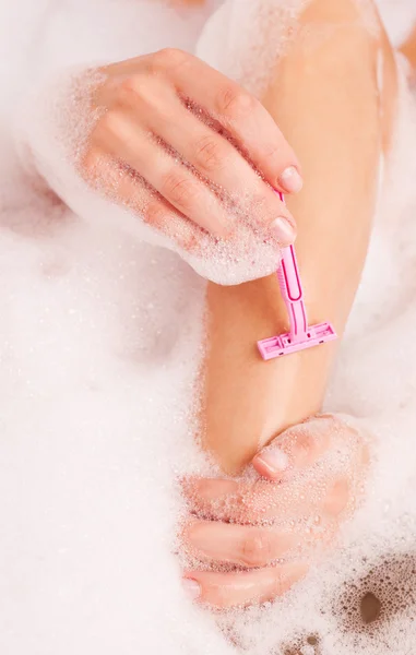 Woman shaving legs — Stock Photo, Image