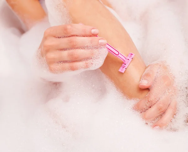 Жінка гоління ніг — стокове фото