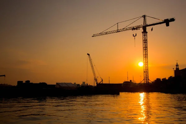 Ipari kikötő naplemente és egy daru — Stock Fotó
