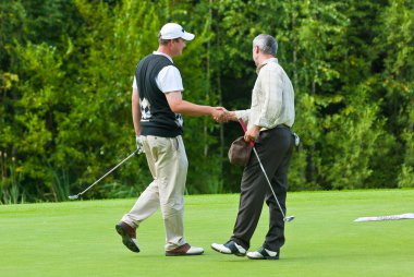 Two Golfers shake hands at Country Club clipart