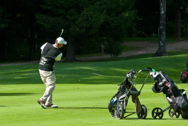 Golfer finishes his swing — Stock Photo, Image