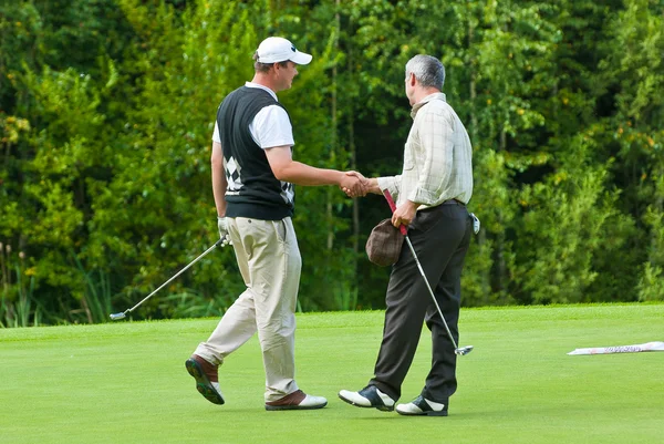 Två golfare skaka hand på country club Stockfoto