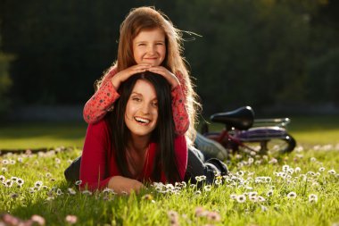 Mother and daughter on a grass clipart