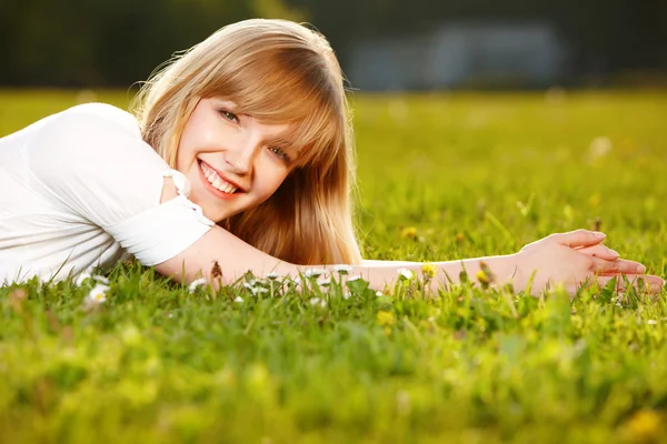 Menina loira bonita em uma grama — Fotografia de Stock