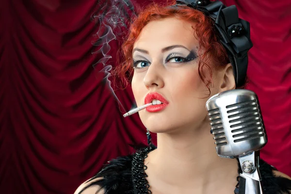 Schöne rothaarige Frau raucht Zigarette in der Nähe von Vintage-Mikrofon — Stockfoto