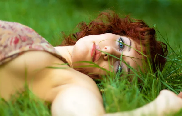 stock image Portrait of beautiful redhead woman lying on grass
