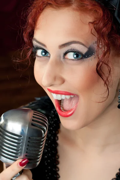 Redhead vrouw zingen in vintage microfoon — Stockfoto
