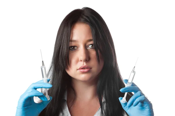 Молода приваблива медсестра тримає два шприци ізольовані на білому тлі — стокове фото