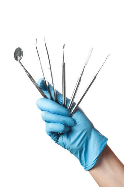 Mão na luva azul segurando ferramentas dentárias isoladas no fundo branco — Fotografia de Stock