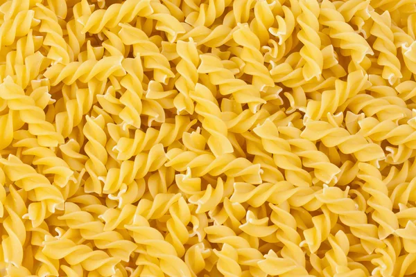 stock image Italian pasta fusilli yellow background