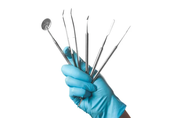 Рука в синей перчатке, держащие стоматологические инструменты изолированы на белом фоне — стоковое фото