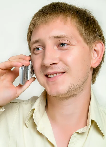Wesoły młody człowiek mówi przez telefon — Zdjęcie stockowe