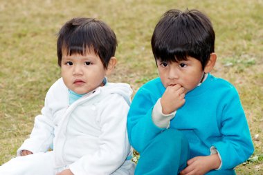 Latin brothers sitting in the park clipart