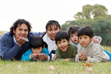 Happy Latin family in the park clipart