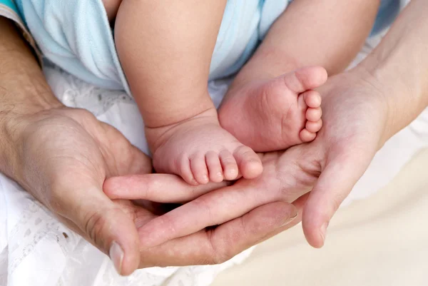 Elterliche Hände halten Beine des Babys — Stockfoto