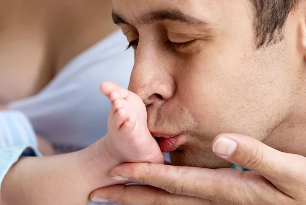 Närbild av fadern av barnet kyssar ett ben — Stockfoto