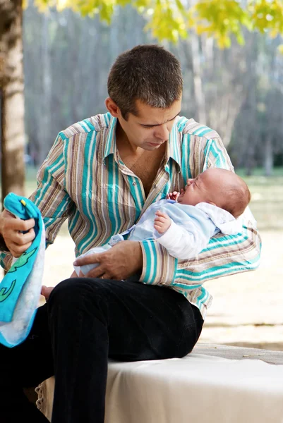 Vardagliga problem. Fadern med den nyfödde son i park — Stockfoto