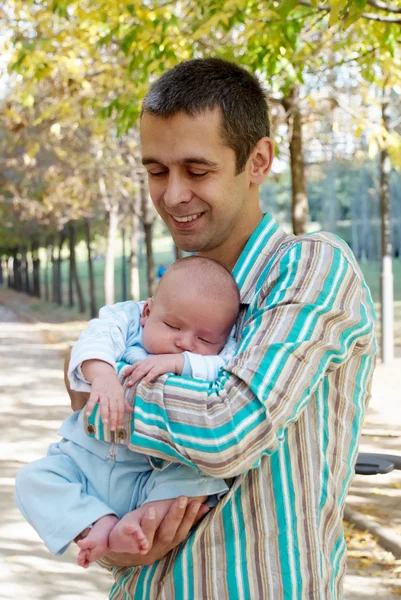 O pai com o filho recém-nascido no parque — Fotografia de Stock