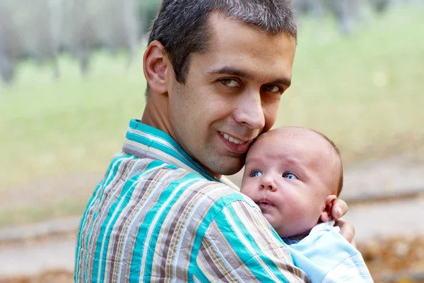 Faren med den nyfødte sønnen i parken. – stockfoto
