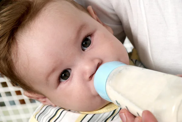 Retrato bebe leche de su biberón — Foto de Stock