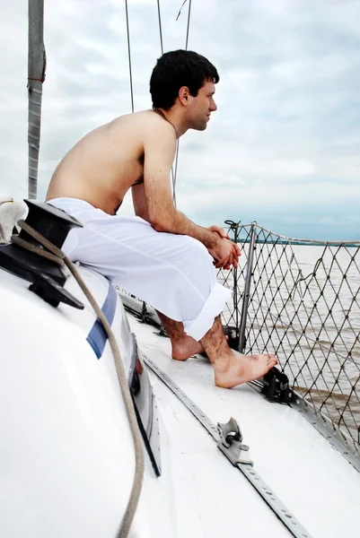 Ο νεαρός άνδρας, που κάθεται επί του σκάφους, σκάφος — Φωτογραφία Αρχείου