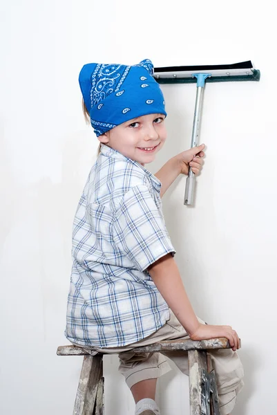 Маленький мальчик моет стену — стоковое фото