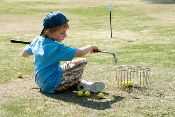 Le petit garçon sur un terrain de golf — Photo