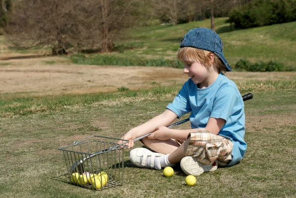 Den lille dreng på en golfbane - Stock-foto