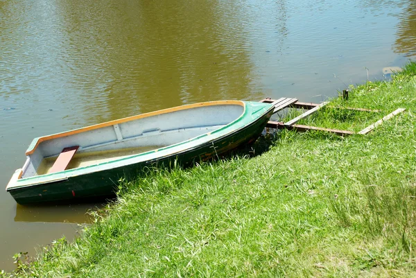 stock image Old fishing boat on the lake bank