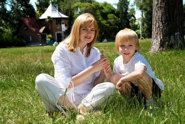 Мать и сын на поляне возле дома — стоковое фото