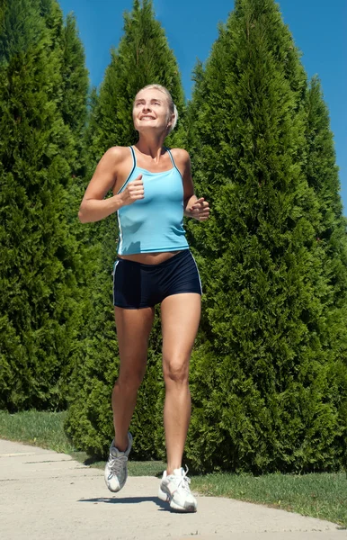 Mujer corriendo al aire libre en el parque verde en el soleado día de verano —  Fotos de Stock