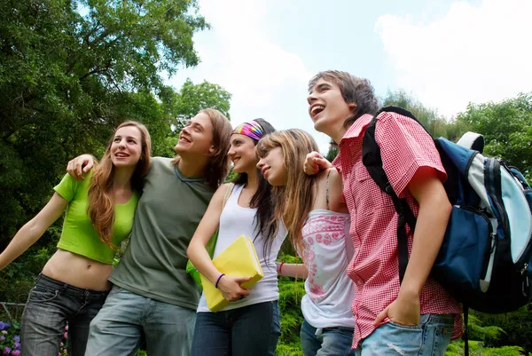 Щасливі молоді студенти в парку — стокове фото