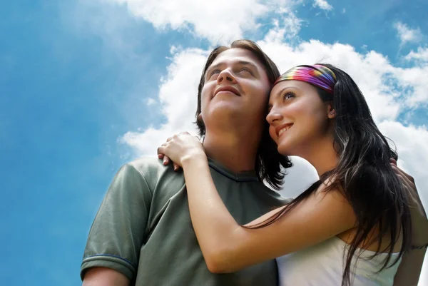 Ευτυχισμένο νεαρό ζευγάρι ενάντια στον ουρανό — Φωτογραφία Αρχείου