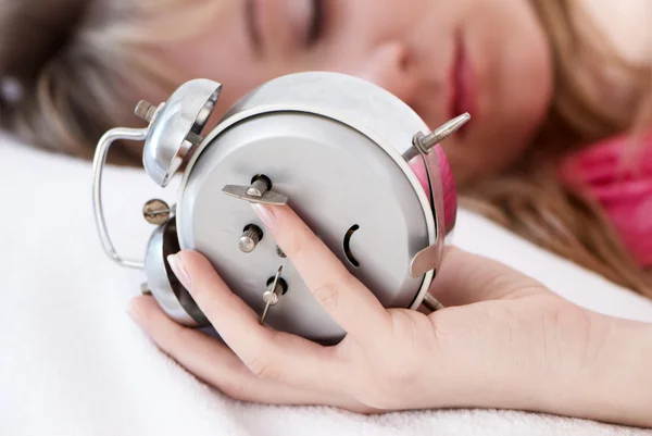 Young beautiful girl switching off alarm clock — Stock Photo, Image
