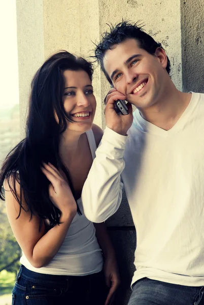 Happy νεαρό ζευγάρι στο δρόμο με το κινητό τηλέφωνο — Φωτογραφία Αρχείου