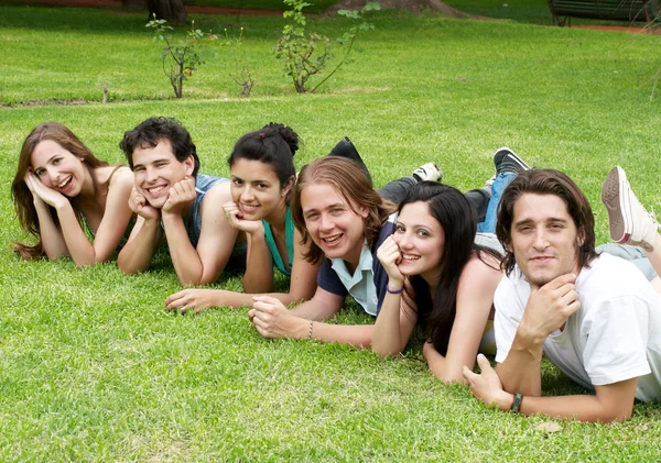 Щаслива група друзів, посміхаючись на відкритому повітрі в парку — стокове фото