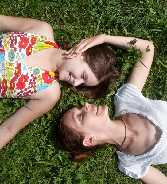 Счастливая мать с дочерью, лежащей на траве в парке — стоковое фото