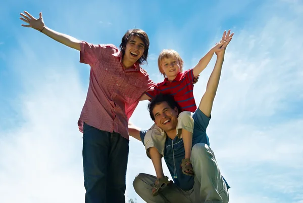 Three brothers of different return against the sky — Stock Photo, Image