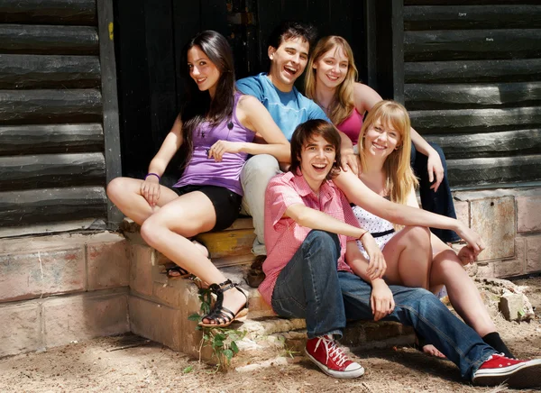 Gelukkig groep vrienden glimlachend buitenshuis — Stockfoto