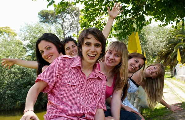 Arkadaşlar açık havada bir parkta gülümseyerek mutlu grup — Stok fotoğraf