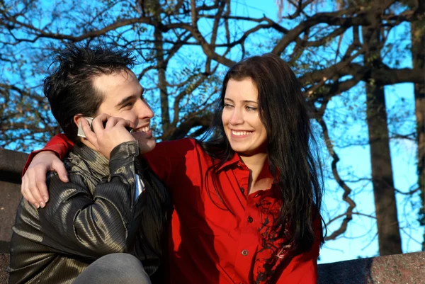 Happy young couple on park with cellphone — Stock Photo, Image