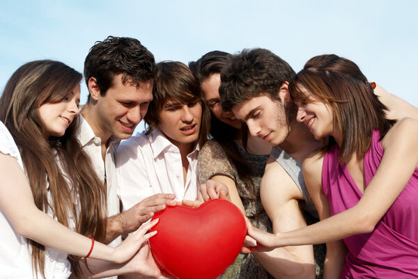 Группа молодых парней и девушек со сферой в виде слуха
